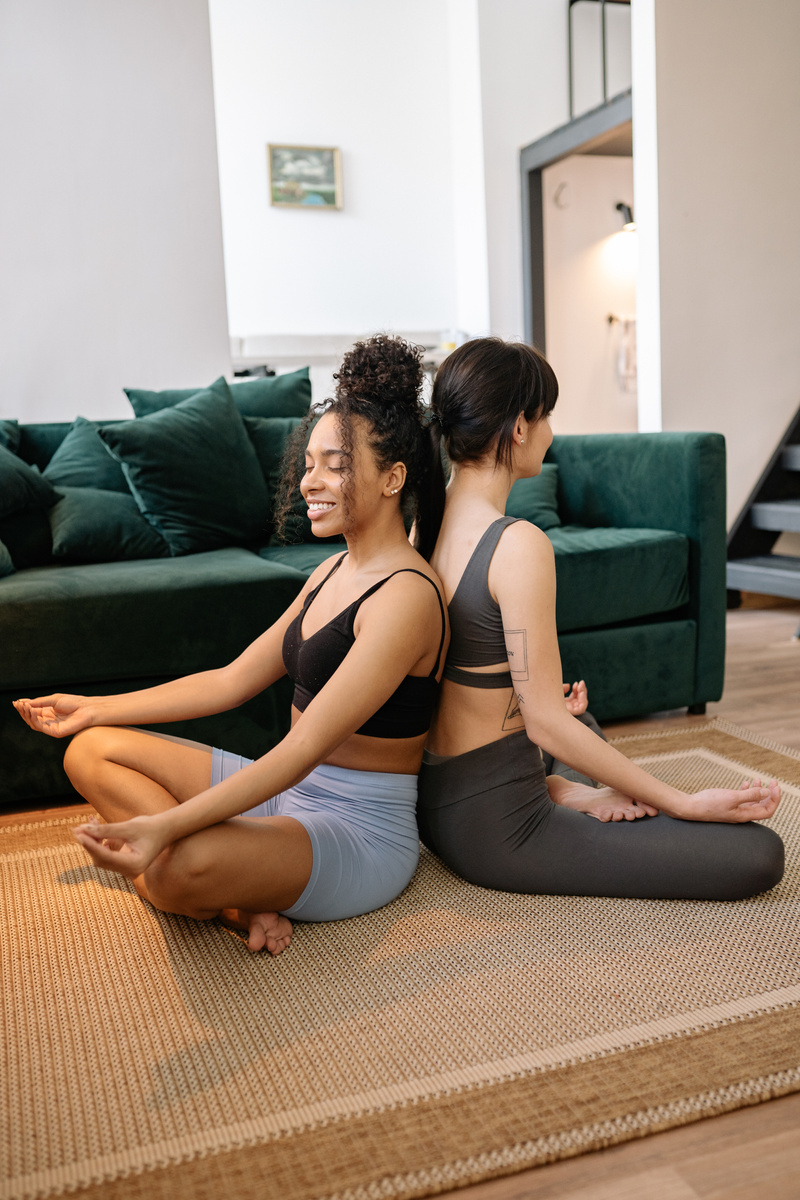 Woman in Lotus Pose Sitting Back to Back